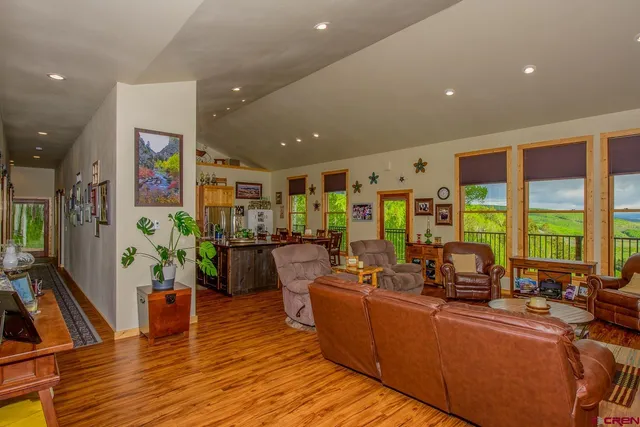 a living room with furniture floor to ceiling window and wooden floor