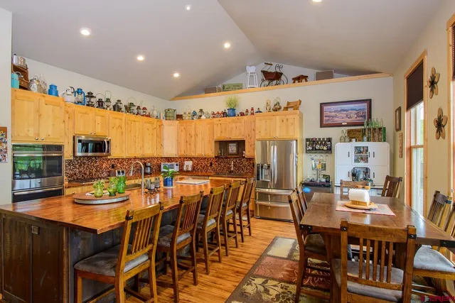 a dining room with stainless steel appliances a table and chairs