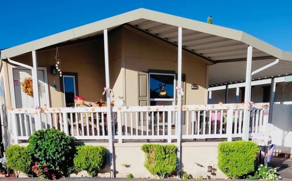 a view of a house with a small yard and wooden floor and fence
