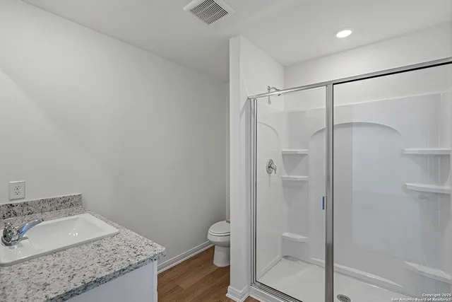a bathroom with a granite countertop sink toilet and shower