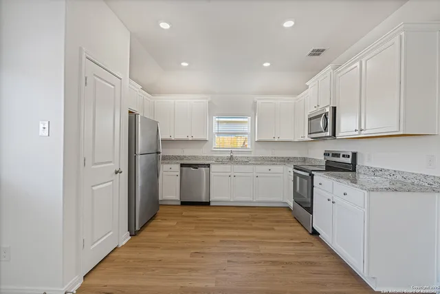 a kitchen with stainless steel appliances granite countertop a refrigerator sink and cabinets