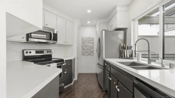 a kitchen that has a sink a stove and a refrigerator
