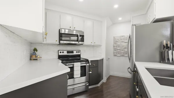 a kitchen with stainless steel appliances a stove a sink and a refrigerator