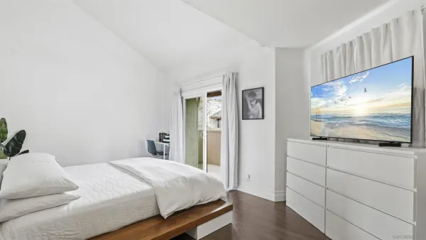 a bedroom with a bed and a flat screen tv