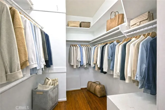 a view of walk in closet with clothes and shoes