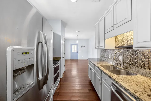 a kitchen with white cabinets and stainless steel appliances