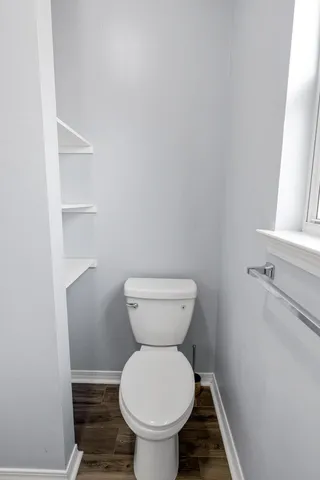 an empty room with wooden floor and white walls