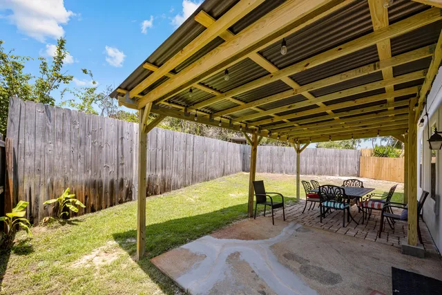 a view of a backyard with table and chairs with wooden floor