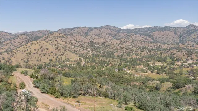 a view of a dry yard with mountains in the background