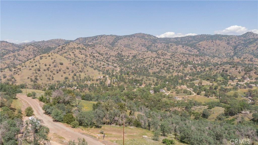 a view of a dry yard with mountains in the background