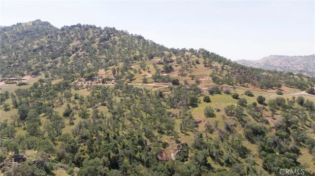 a view of a dry yard with mountains in the background