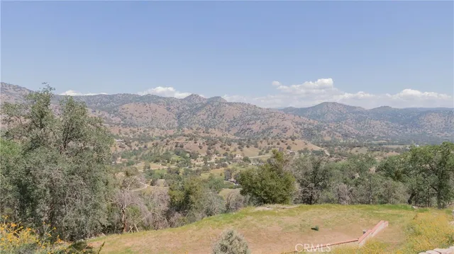 a view of a dry yard with mountains in the background