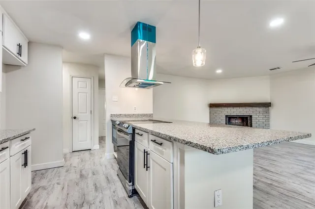 a kitchen with a stove and a wooden floor