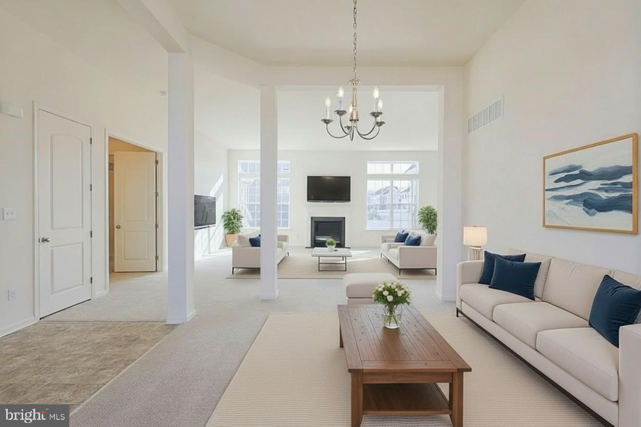 910 Weatherstone Lane Felton, DE 19943 - Photo 4 of 29 a living room with furniture chandelier and a fireplace