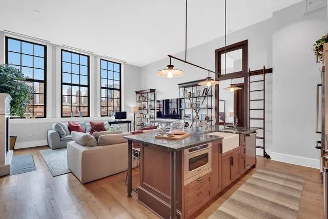 a open kitchen with stainless steel appliances granite countertop a stove and a large window