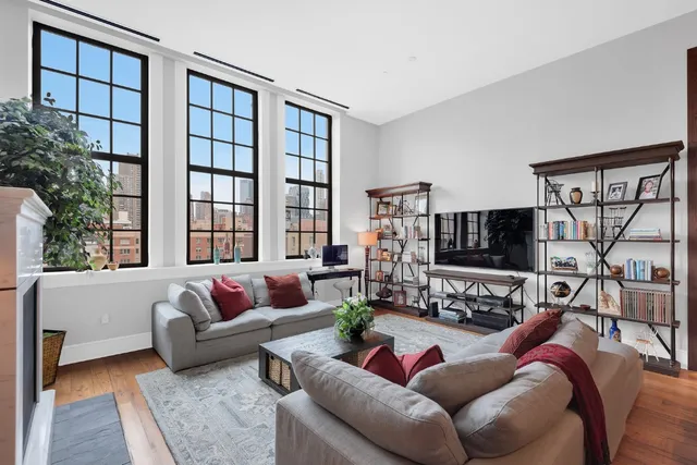 a living room with furniture a floor to ceiling window and a flat screen tv