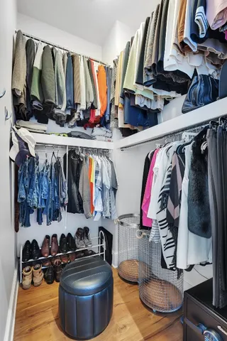 a view of walk in closet with clothes and shoes