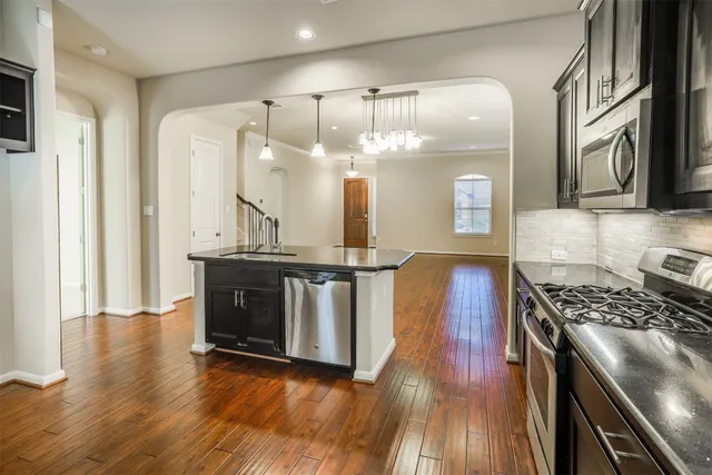 a kitchen with stainless steel appliances granite countertop a stove and a wooden floors