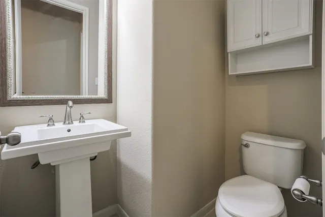 a bathroom with a sink a toilet and mirror