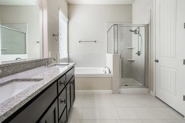a bathroom with a granite countertop sink a mirror and a bathtub