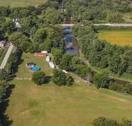 an aerial view of residential houses with outdoor space and trees