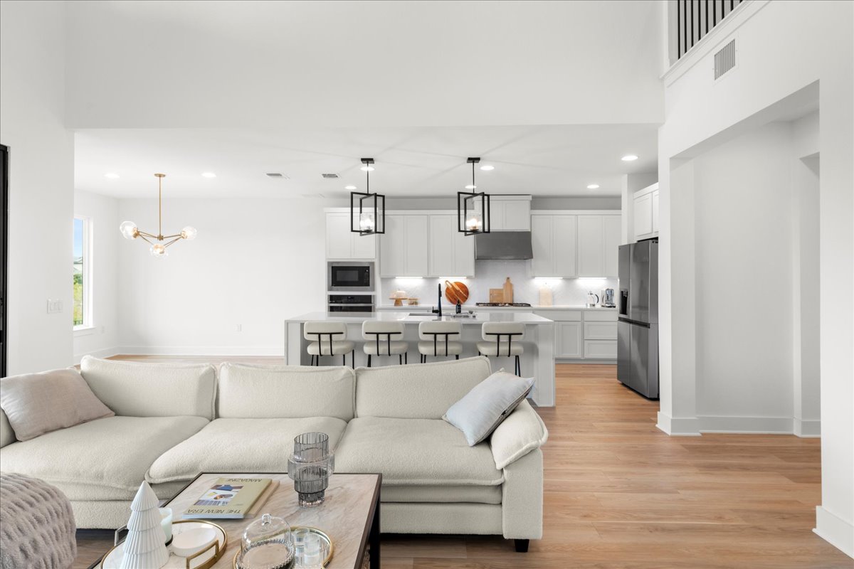 8700 Olmsted Way Austin, TX 78744 - Photo 14 of 40 Living room with recessed lighting, light wood finished floors, and a chandelier
