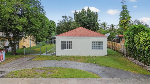 a view of a house with a yard and large tree