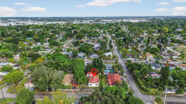 an aerial view of residential houses with outdoor space and trees
