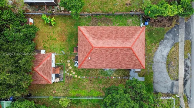 an aerial view of a house with a garden and lake view