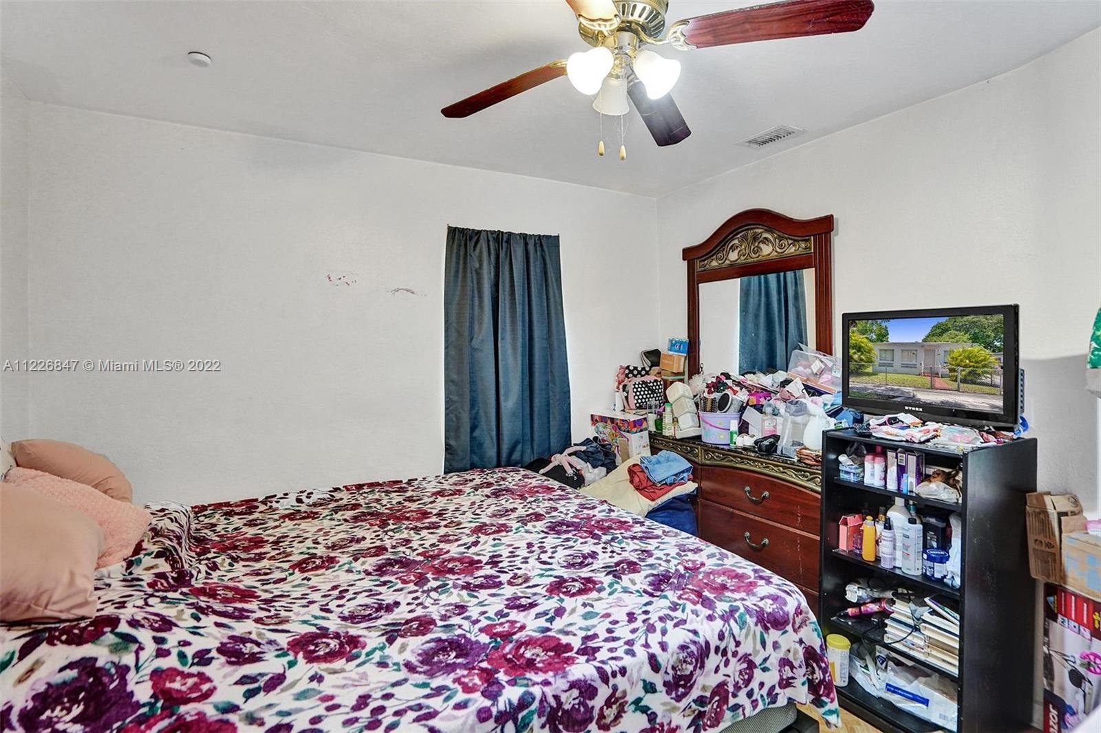 1554 Northwest 58th Street Miami, FL 33142 - Photo 12 of 57 a bedroom with bed and a chandelier