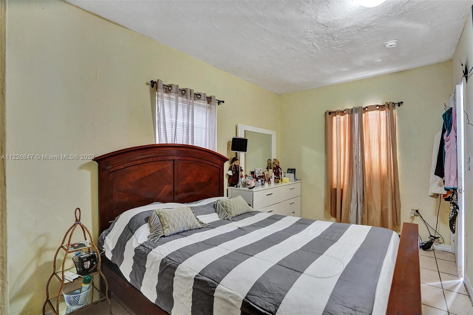 1554 Northwest 58th Street Miami, FL 33142 - Photo 23 of 57 a bedroom with a bed dresser and a large mirror