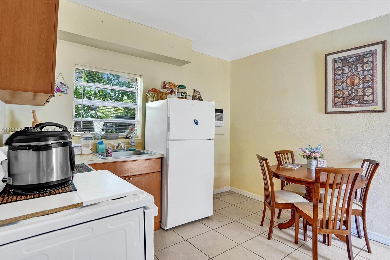 1554 Northwest 58th Street Miami, FL 33142 - Photo 27 of 57 a white kitchen with a stove and a refrigerator