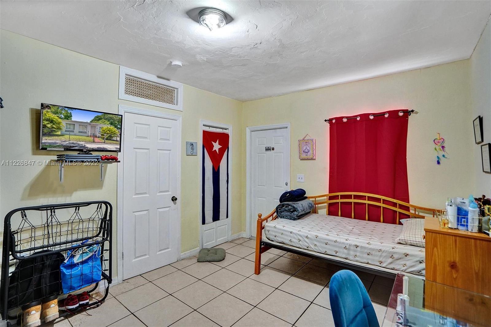 1554 Northwest 58th Street Miami, FL 33142 - Photo 29 of 57 a bedroom with furniture and a mirror