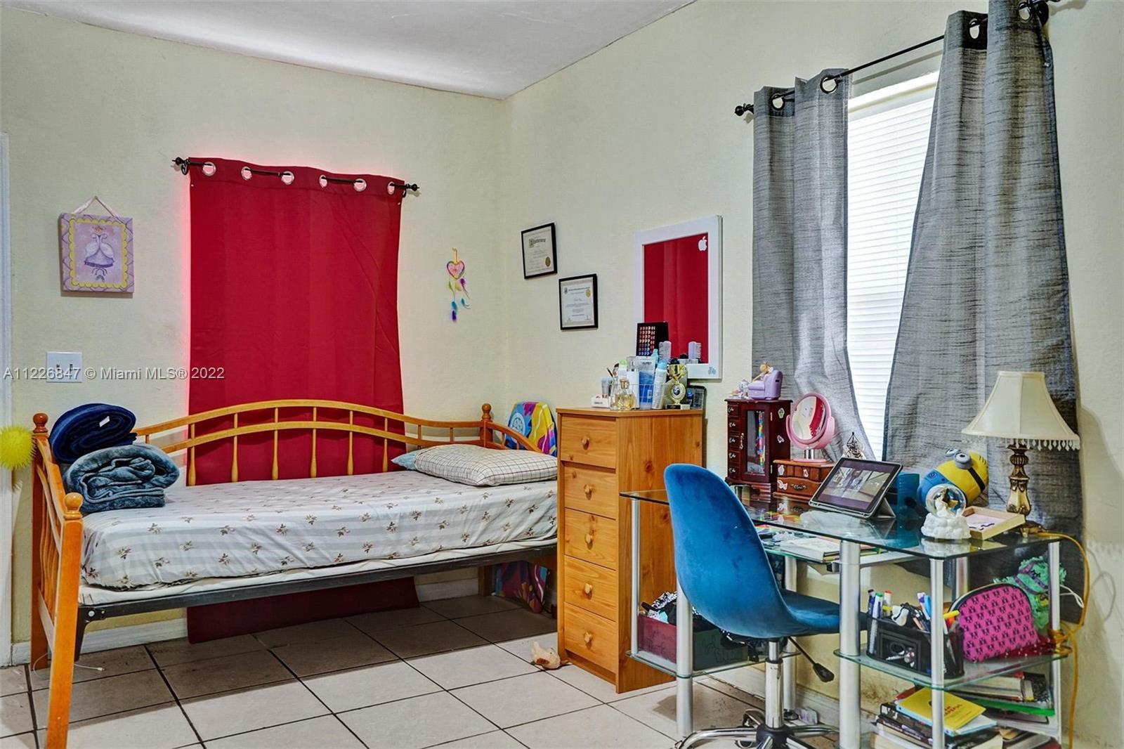 1554 Northwest 58th Street Miami, FL 33142 - Photo 30 of 57 a bedroom with a bed and a table in it