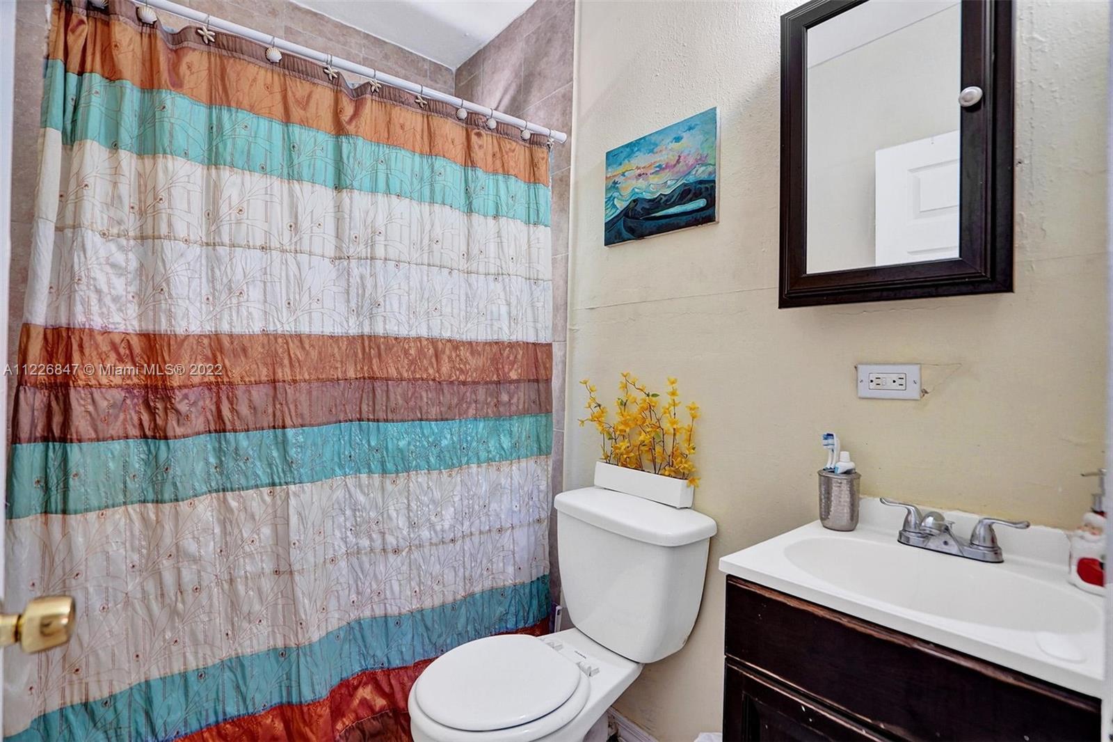 1554 Northwest 58th Street Miami, FL 33142 - Photo 32 of 57 a bathroom with a sink toilet and mirror