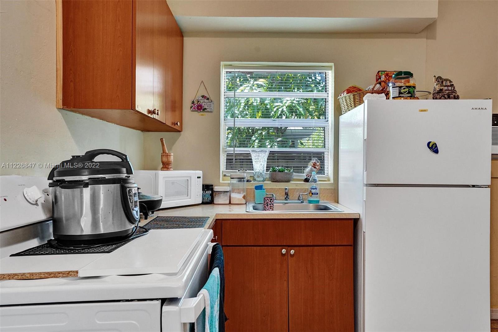 1554 Northwest 58th Street Miami, FL 33142 - Photo 33 of 57 a kitchen with a refrigerator and a sink