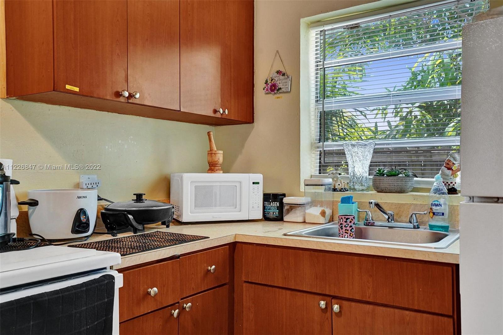 1554 Northwest 58th Street Miami, FL 33142 - Photo 34 of 57 a kitchen with stainless steel appliances granite countertop a sink stove and cabinets
