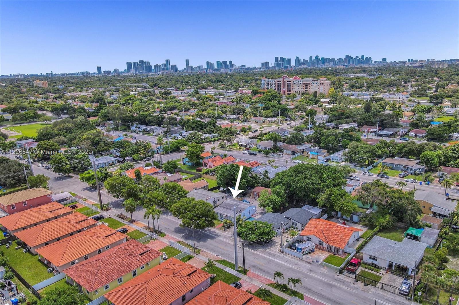 1554 Northwest 58th Street Miami, FL 33142 - Photo 55 of 57 an aerial view of a city with lots of residential buildings ocean and mountain view in back