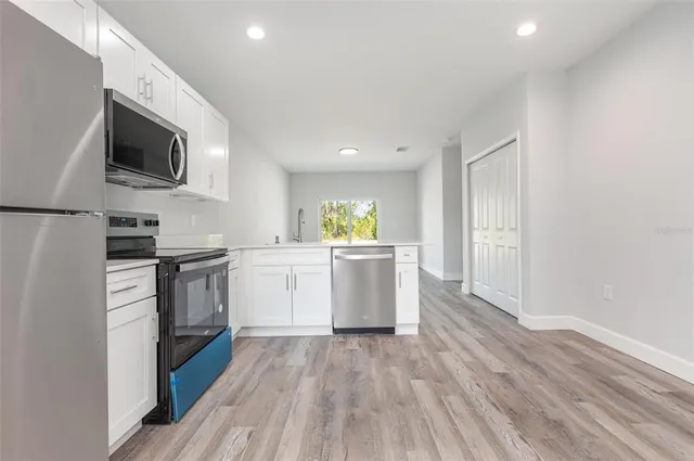 a kitchen with a sink and steel appliances
