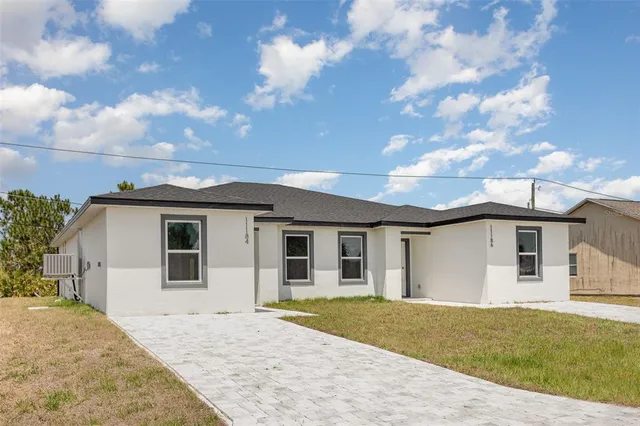 a view of a white house with a yard