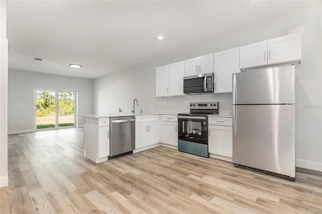 a kitchen with a refrigerator and a stove top oven