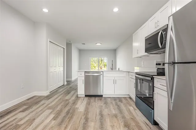 a kitchen with a sink a microwave and cabinets
