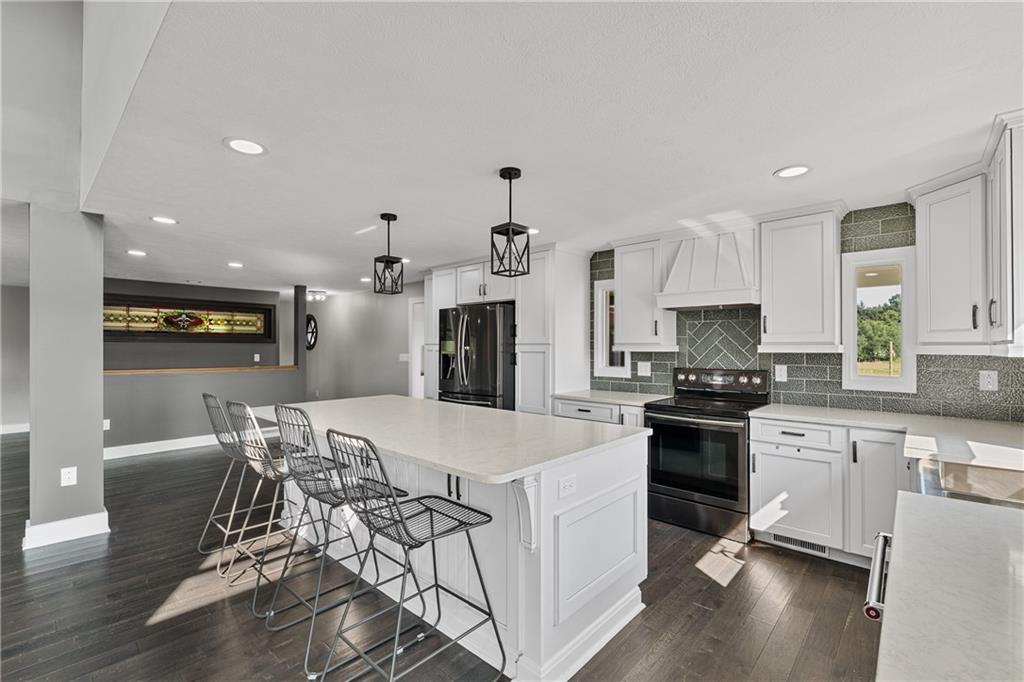 570 Steiner Bridge Road Valencia, PA 16059 - Photo 6 of 35 a large kitchen with granite countertop a stove top oven a sink a dining table and chairs