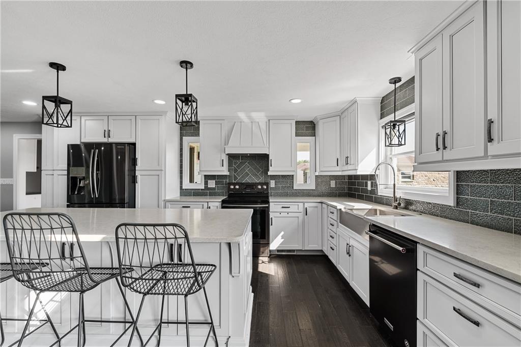 570 Steiner Bridge Road Valencia, PA 16059 - Photo 7 of 35 a kitchen with stainless steel appliances granite countertop a refrigerator a sink dishwasher a stove and white cabinets with wooden floor