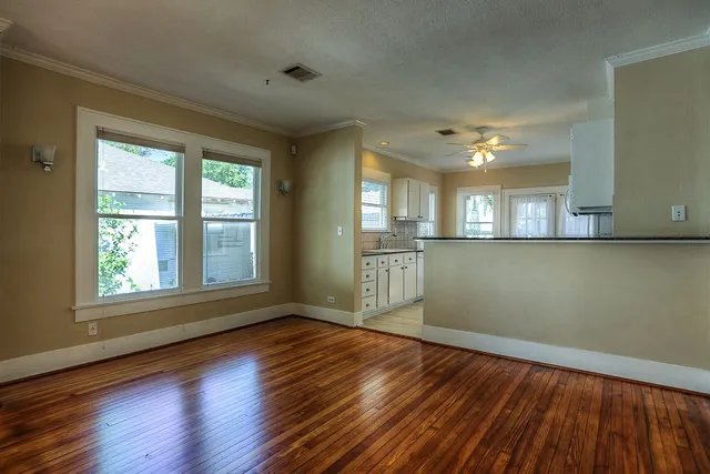 an empty room with wooden floor and windows