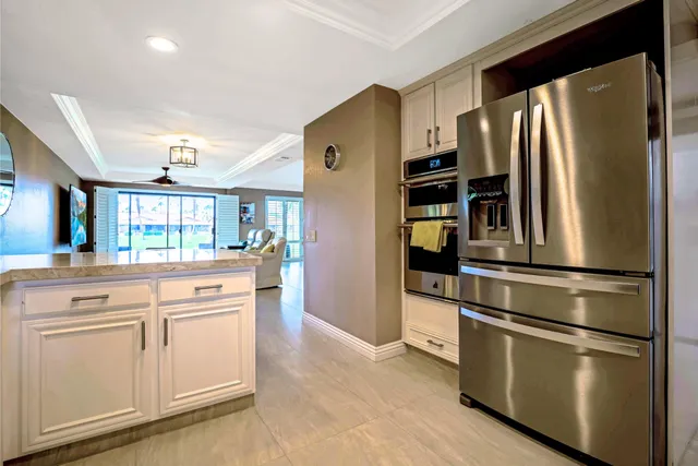 a kitchen with stainless steel appliances white cabinets and a refrigerator