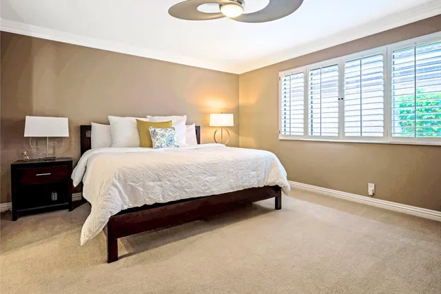 a bedroom with a bed lamp and window