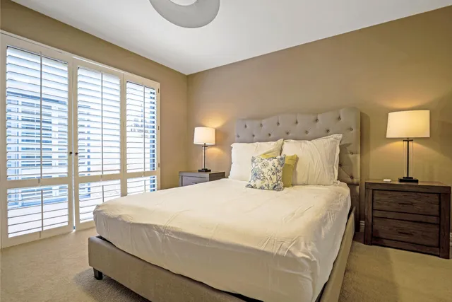 a large bed sitting in a bedroom next to a window