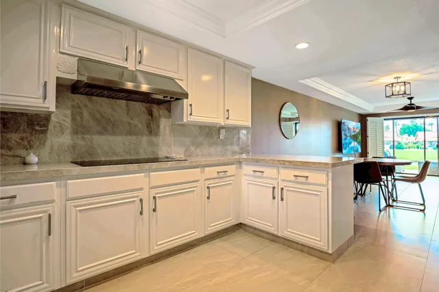 a kitchen with granite countertop white cabinets and white appliances