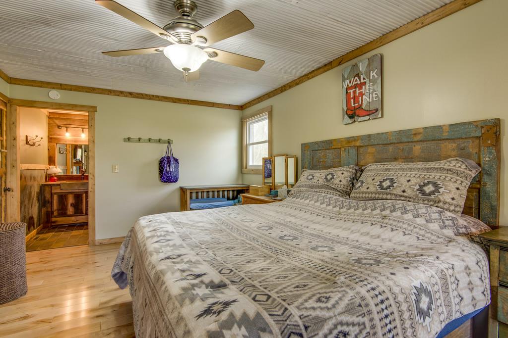 545 Haley Road Burns, TN 37029 - Photo 14 of 30 a bedroom with a large bed and a chandelier
